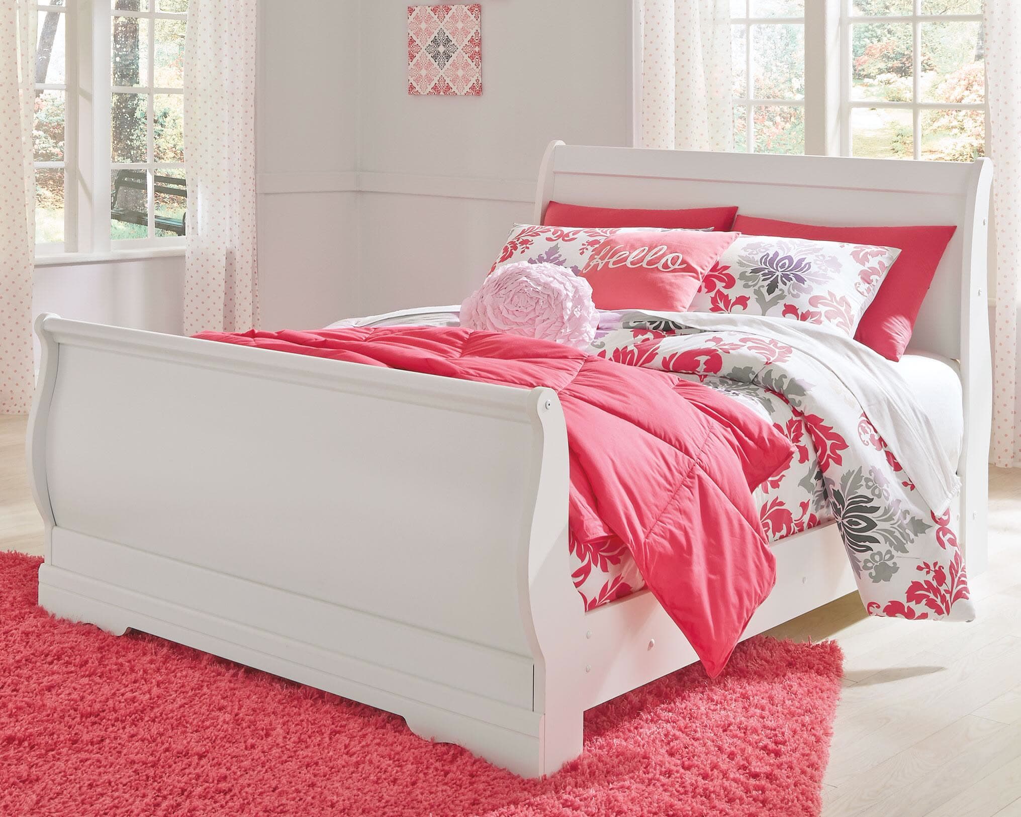 White sleigh bed with floral bedding in a child's bedroom